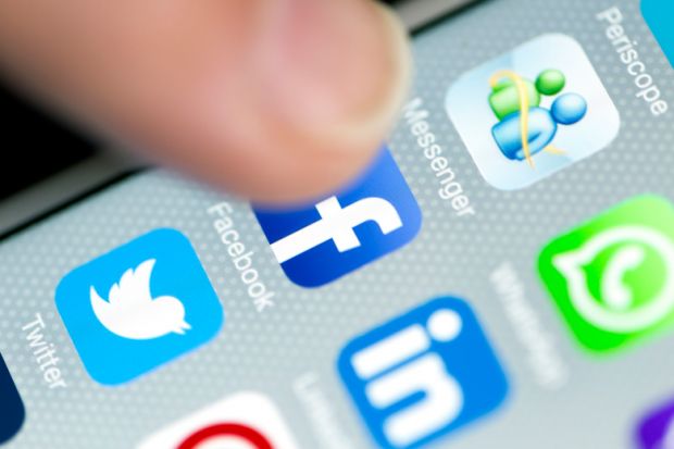 Hand tapping social media icon on smartphone screen