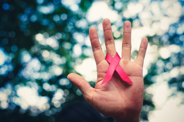 Hand holding AIDS ribbon