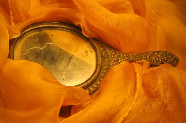 Handheld mirror laid on fabric