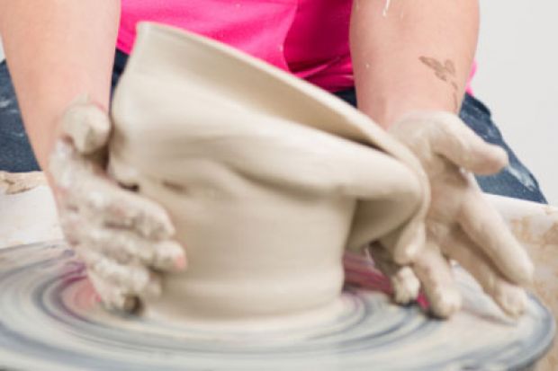 Hands working clay on potter's wheel Hands working clay on potter's wheel