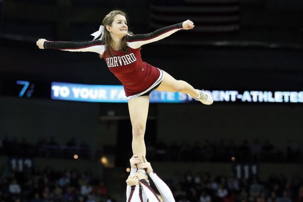 Harvard Crimson cheerleader (Harvard University) being held aloft Harvard Crimson cheerleader (Harvard University) being held aloft