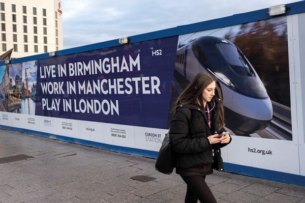 A woman walks in front of a billboard advertising HS2 A woman walks in front of a billboard advertising HS2
