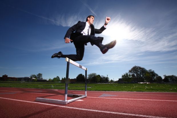 Businessman jumping a hurdle