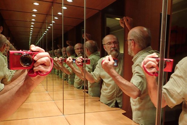 Man taking selfie of reflections in infinity mirror, illustrating tedium when conferences are dominated by authors with multiple papers. Man taking selfie of reflections in infinity mirror, illustrating tedium when conferences are dominated by authors with multiple papers.