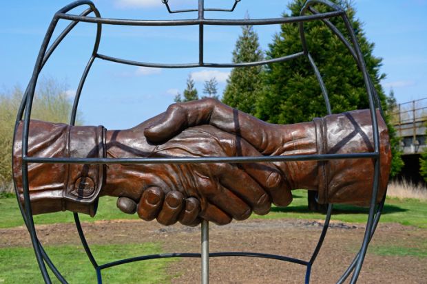 Christmas Truce Memorial showing soldiers handshake within a globe, National Memorial Arboretum. Christmas Truce Memorial showing soldiers handshake within a globe, National Memorial Arboretum.