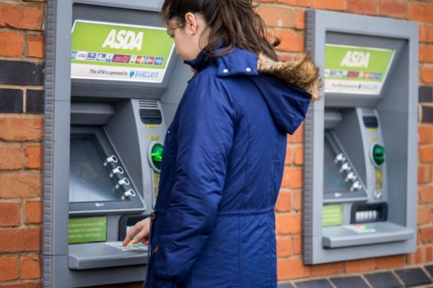 Young adult woman withdrew from cash machine.