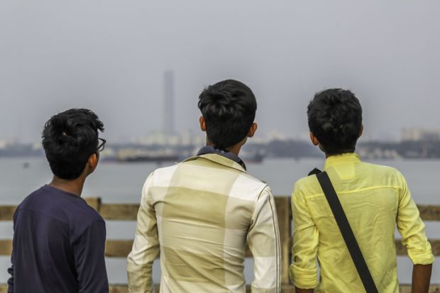Group of three friends having fun at sunset time.