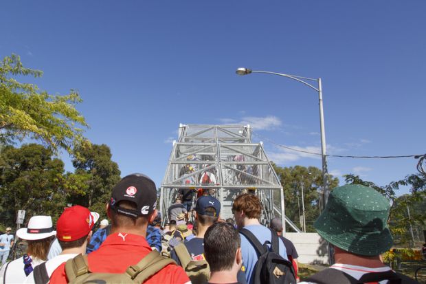 Race day at Melbourne's Motor Show. Spectators make their way safely over the footbridge to Albert Park.