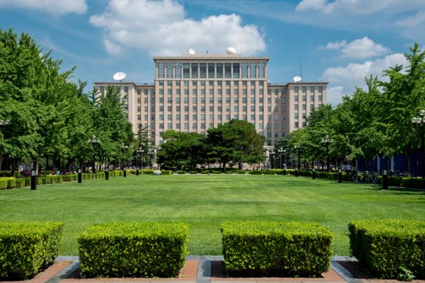 Green gardens and the main Building of the famous Tsinghua University in Beijing, China.