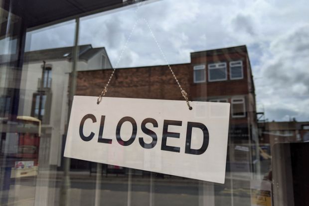 A closed sign hanging in a shop window