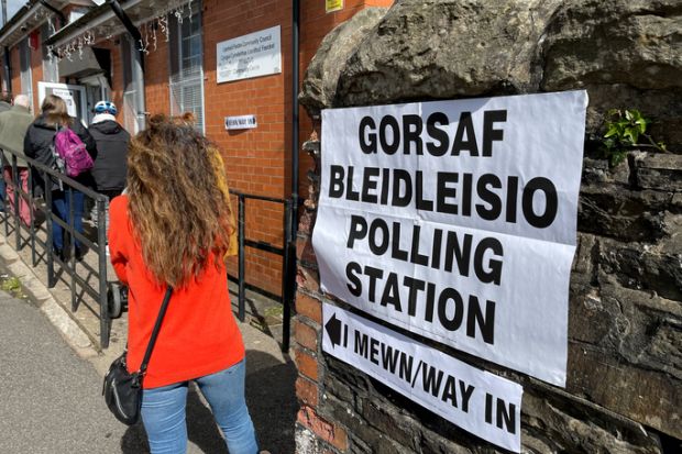 Queue of people waiting to enter a polling station in a village hall Queue of people waiting to enter a polling station in a village hall