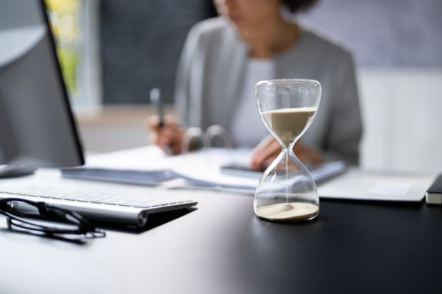 Hourglass on desk running out Hourglass on desk running out