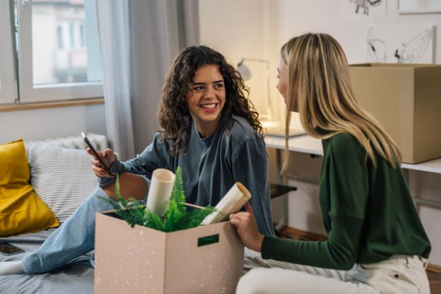 Two young women unpacking in a room Two young women unpacking in a room
