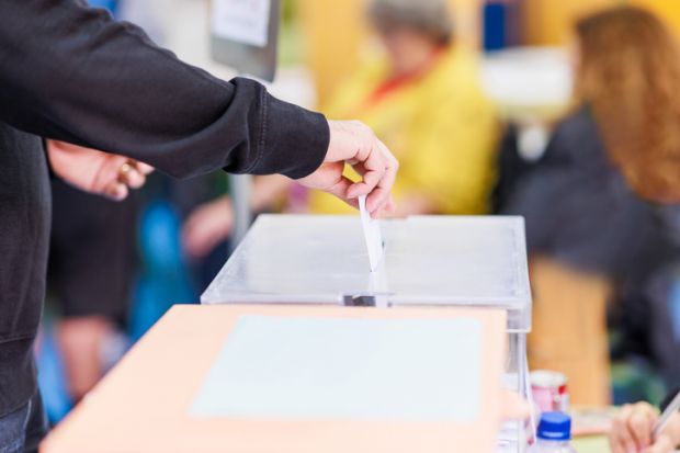 Person putting polling card in ballot box