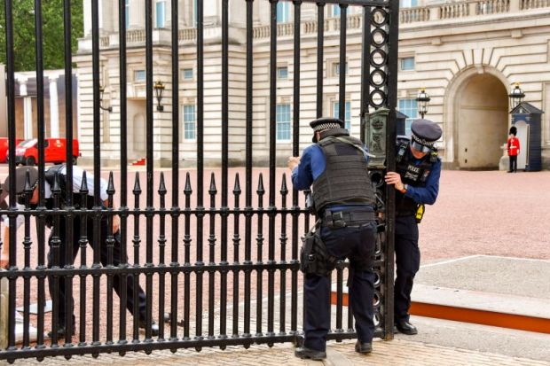 Police officers trying to close one of the gates of Buckingham Palace