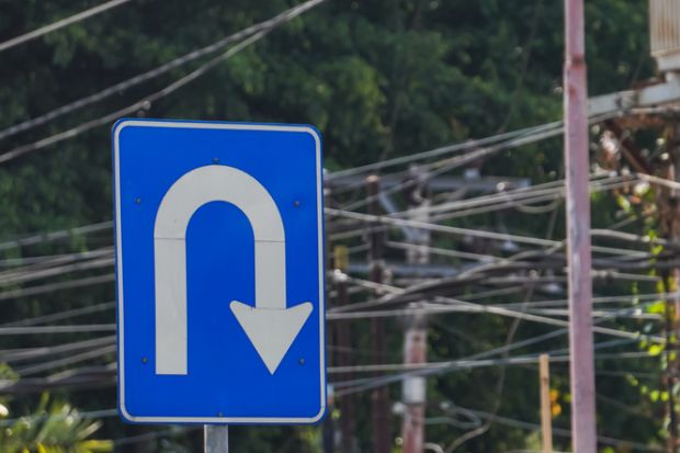 Right U turn sign on blue colored board with cityscape backgrounds.