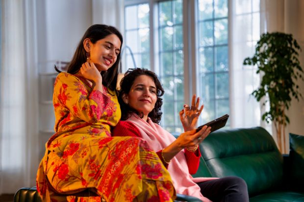 Mother and daughter browsing a smartphone together