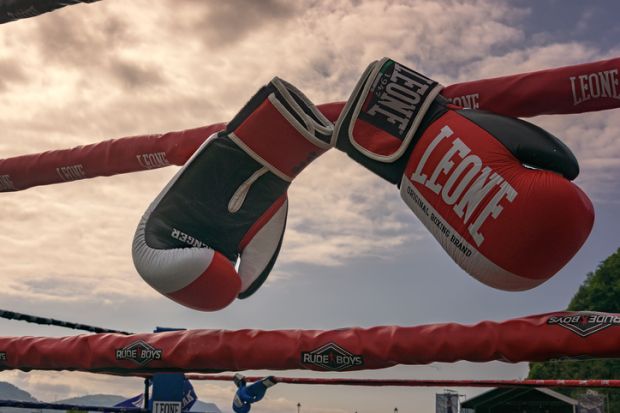 boxing gloves hanging on the ring ropes prepared for an outdoor evening. Boxing gloves hanging on the ring ropes prepared for an outdoor evening.
