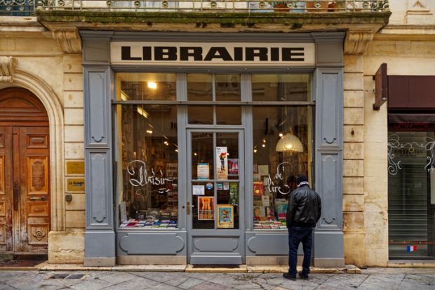 1 person is looking into an old bookstore