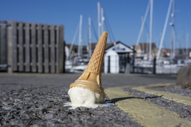 A dropped ice cream cone melting on a sunny road