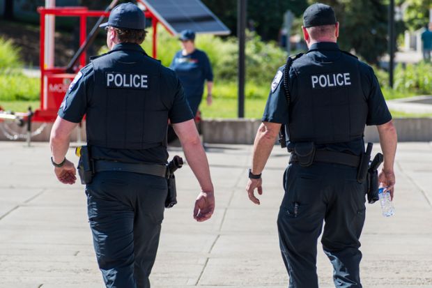 Police Officers Walking Through City Park