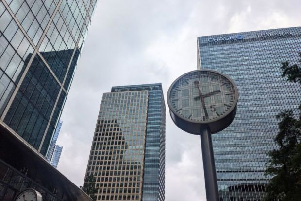 A public clock stands at Reuters Plaza before the modern glass skyscrapers, including the JP Morgan Chase building, in the Canary Wharf financial district 