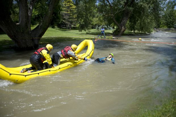 A rescue team readies to pull a mock victim to safety during a Swift Water Rescue training exercise.