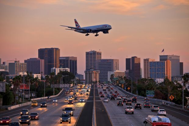 British Airways Boeing 777 flying over crowded freeway to land at Lindberg Field San Diego International Airport. British Airways Boeing 777 flying over crowded freeway to land at Lindberg Field San Diego International Airport.