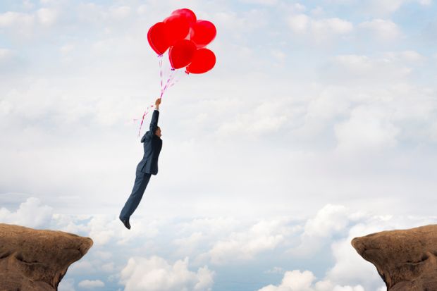 Man floating over crevasse on balloons