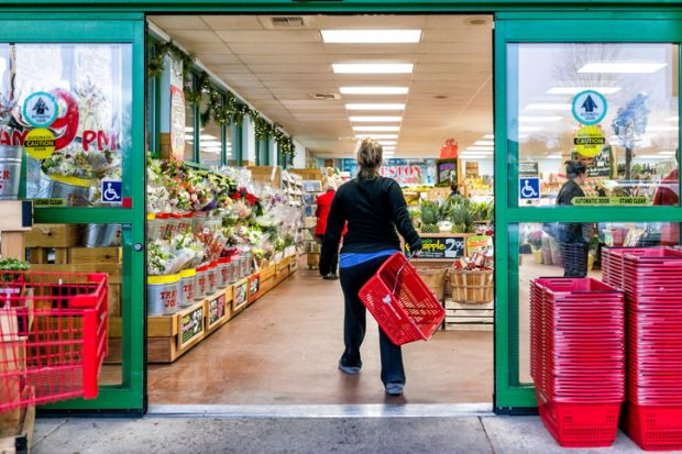 Trader Joe's customer with shopping basket by store entrance