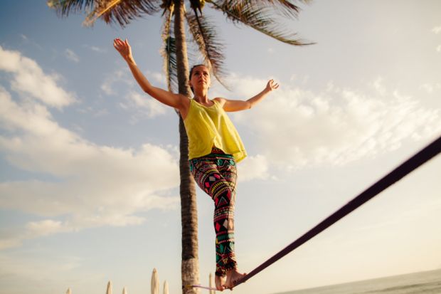 Teenage girl balancing on slack line