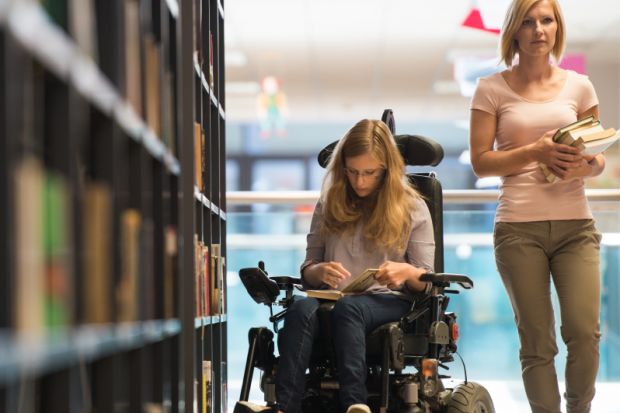 Woman in wheelchair in library Woman in wheelchair in library