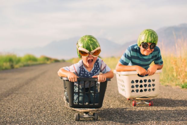 Young boys racing wearing watermelon helmets