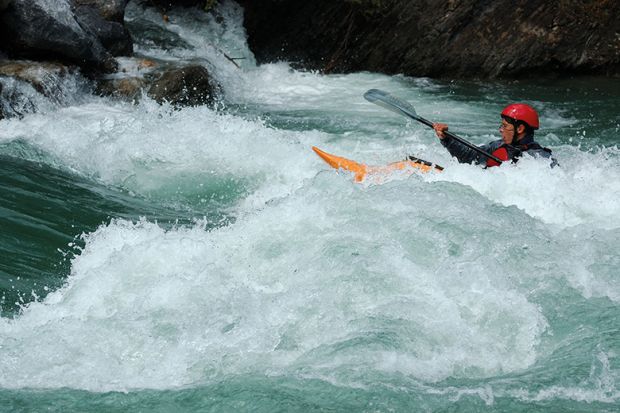 Person in a kayak paddling upstream. To illustrate that a one-off inflationary tuition fee rise will do little to help the financial instability of the higher education sector in England Person in a kayak paddling upstream. To illustrate that a one-off inflationary tuition fee rise will do little to help the financial instability of the higher education sector in England
