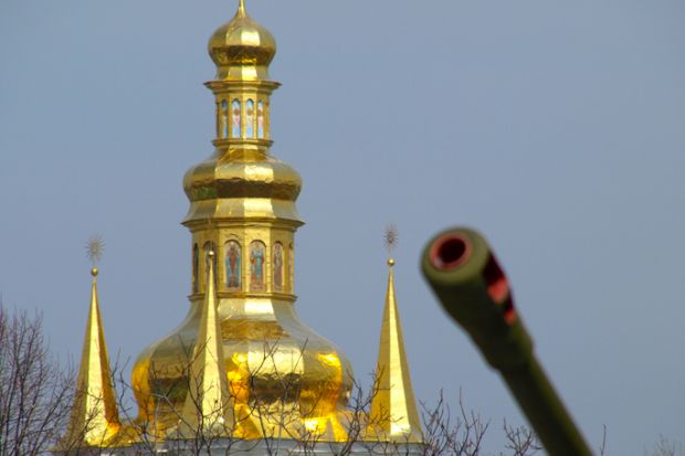 A Kyiv church with a tank gun in the foreground, illustrating the war in Ukraine