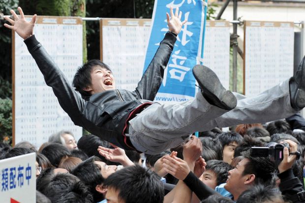 Laughing student being thrown in air by friends Laughing student being thrown in air by friends