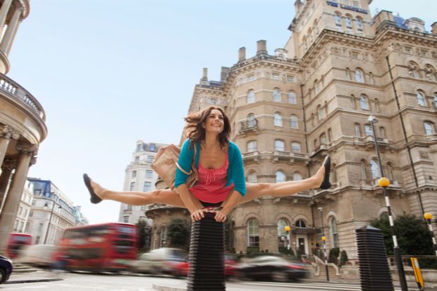 A woman leapfrogs a bollard in London A woman leapfrogs a bollard in London