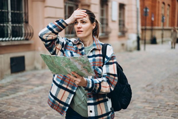 A woman with a map looking lost, sybolising geography department closures