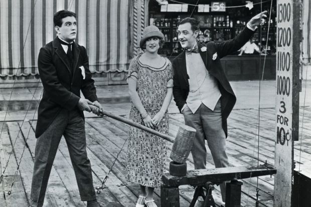 Man attempting strength test at amusement park Man attempting strength test at amusement park