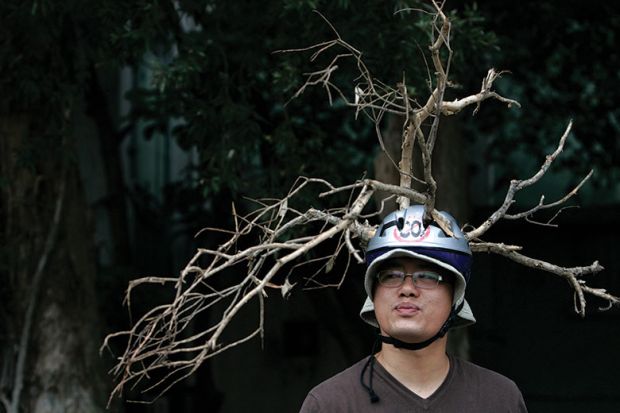 Man wears helmet with branches attached Man wears helmet with branches attached