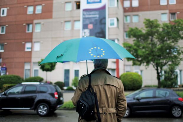 Man carrying a European Union (EU)-branded umbrella Man carrying a European Union (EU)-branded umbrella