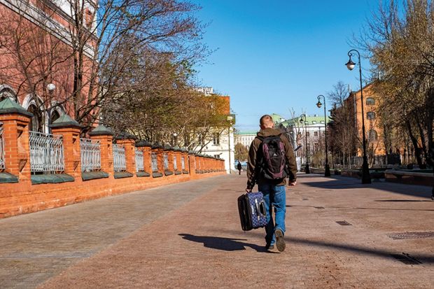 Moscow, Russia. A man carries a suitcase in the street. To illustrate an exiled Russian scholar. Moscow, Russia. A man carries a suitcase in the street. To illustrate an exiled Russian scholar.
