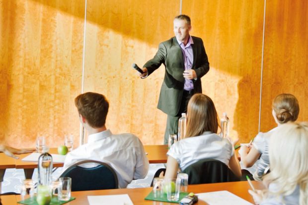 Man handing microphone to audience member Man handing microphone to audience member