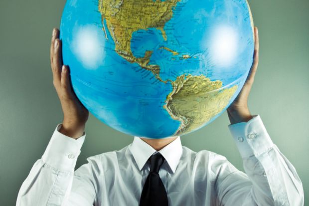 Man holding globe in front of face Man holding globe in front of face