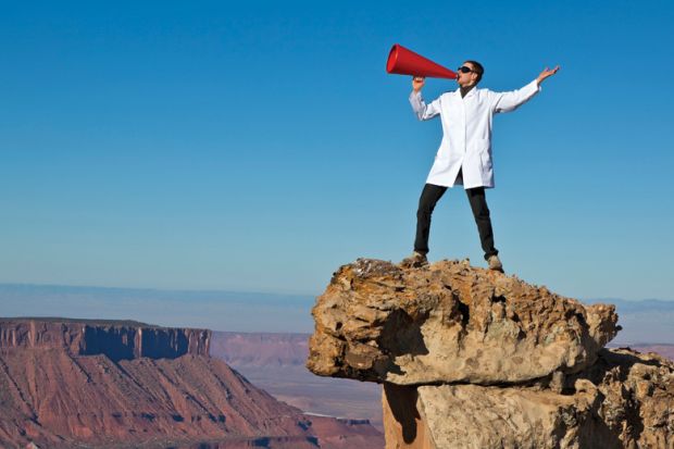 Man in lab coat shouting from rock with megaphone Man in lab coat shouting from rock with megaphone