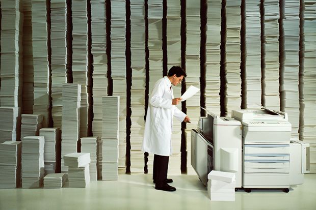Man in white coat photocopying, illustrating the burden of administrative tasks in academia.