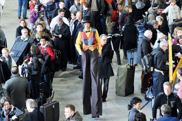 Man on stilts walking through crowd Man on stilts walking through crowd