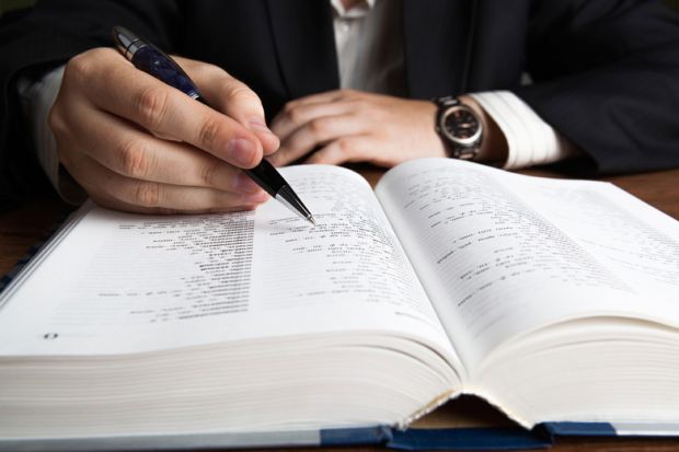 Man scanning dictionary page with pen Man scanning dictionary page with pen