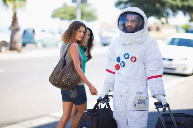 Man walking on street dressed as astronaut Man walking on street dressed as astronaut