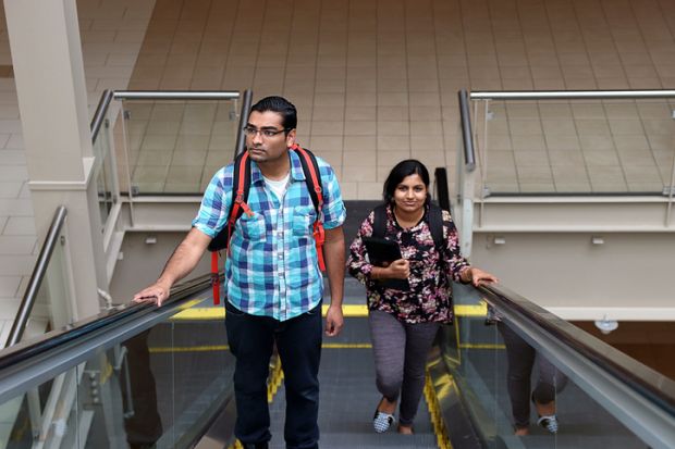Man and woman going up escalator